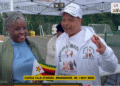 Diaspora Insurance client shares her positive experience at the Zimbabwe Inter-School Games in Birmingham 2025, holding a Zimbabwean flag alongside a Diaspora Insurance team member.