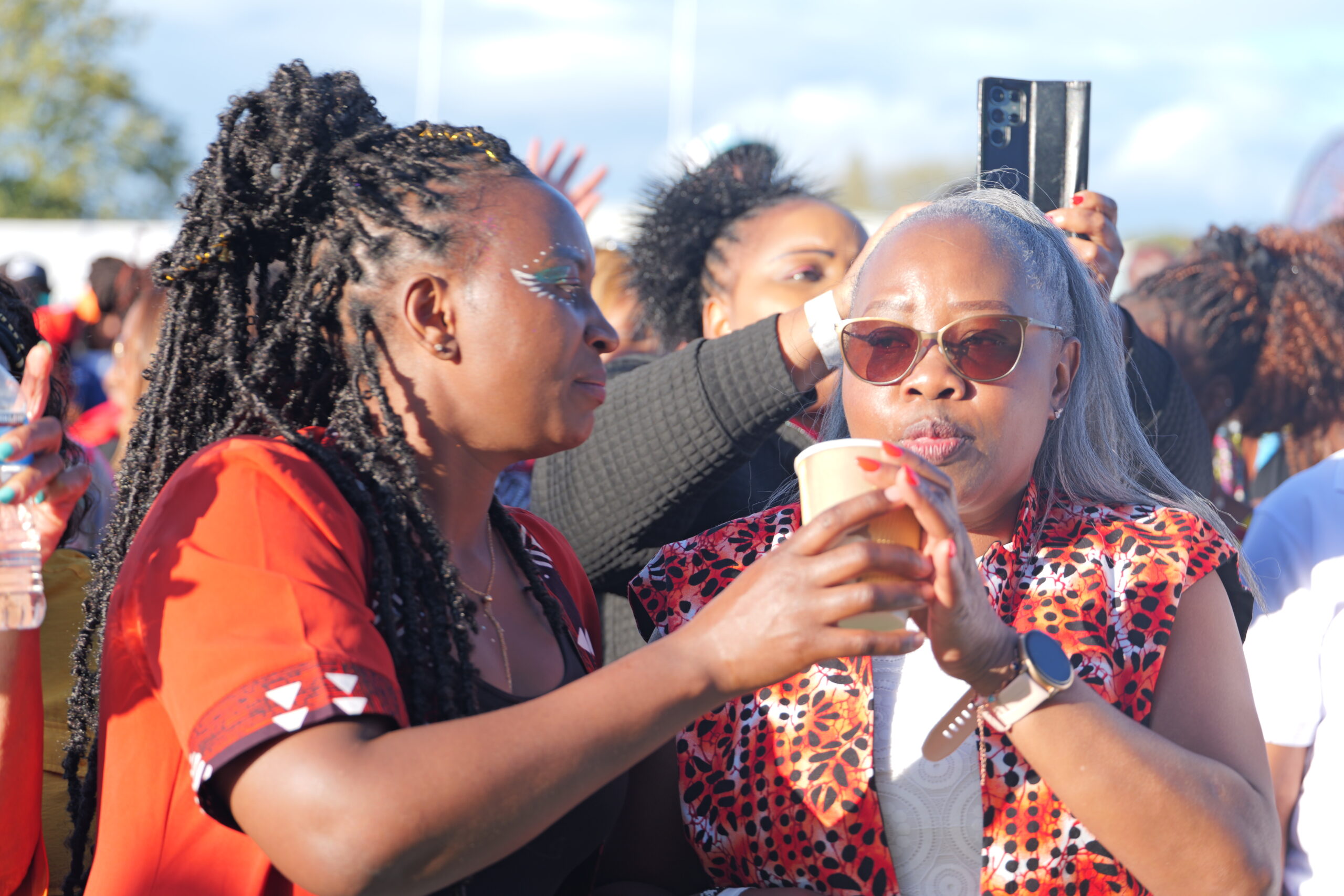 Two women enjoying drinks and conversation at Ngemi Cia UK Homecoming Festival 2025, a celebration of culture and community supported by Diaspora Insurance.