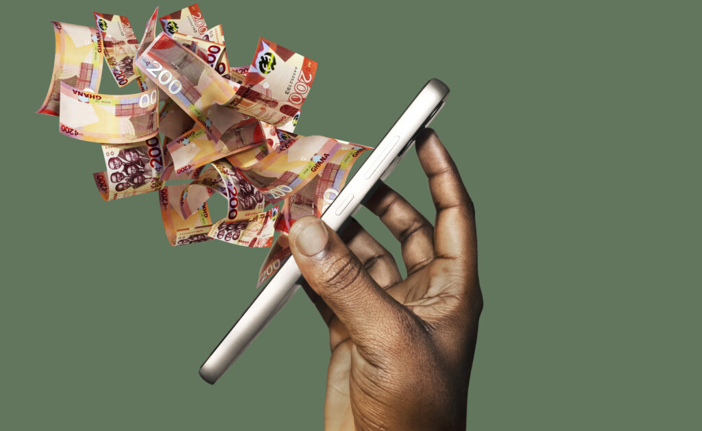 A hand holding a smartphone with Ghanaian cedi notes flowing out, symbolising how Africans abroad support family back home through remittances, featured by Diaspora Insurance.