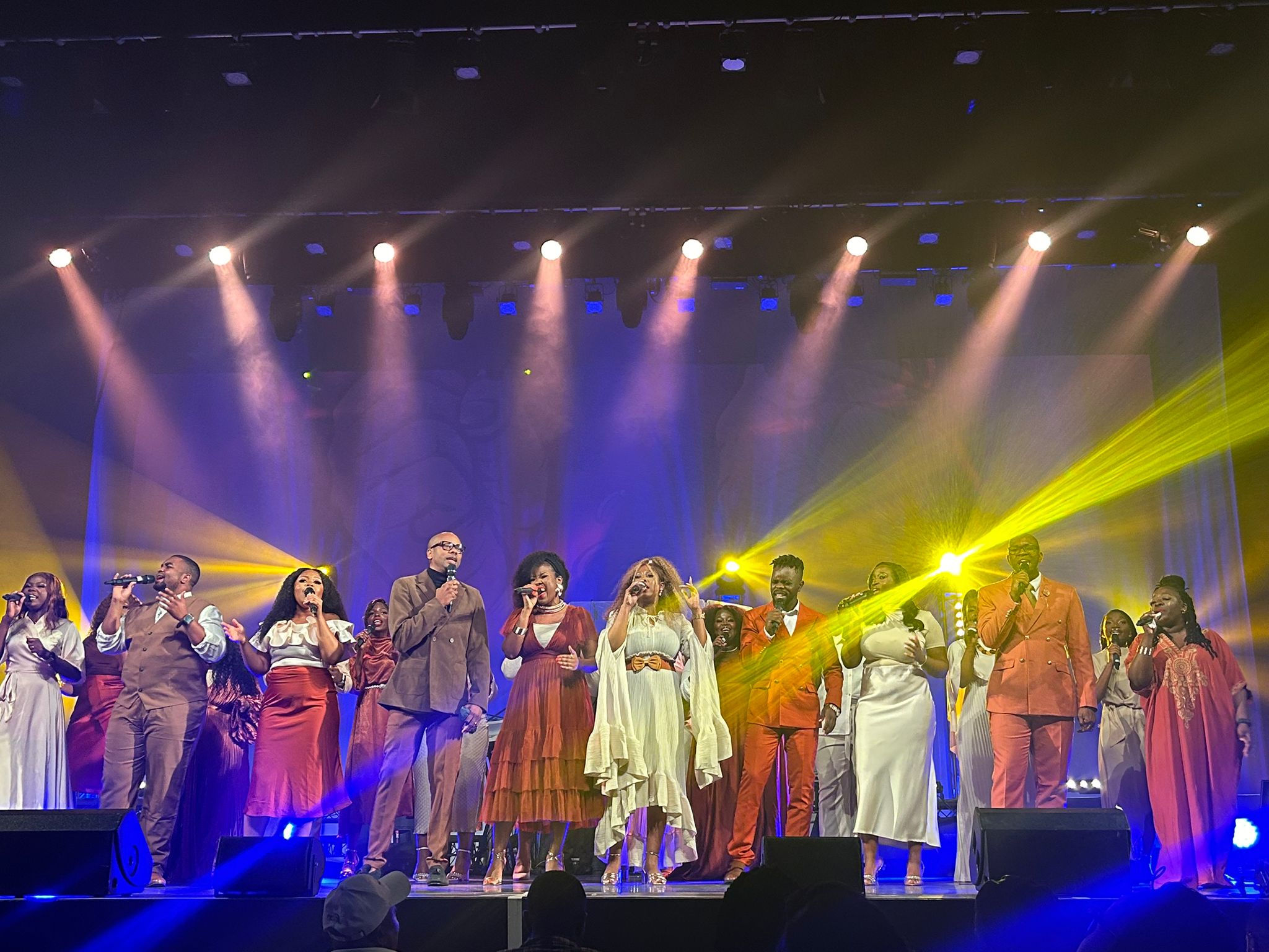Free to Worship choir performing live on stage at the FIFMI Australia Believers Convention during the Free to Worship Legacy Concert, under vibrant stage lighting.