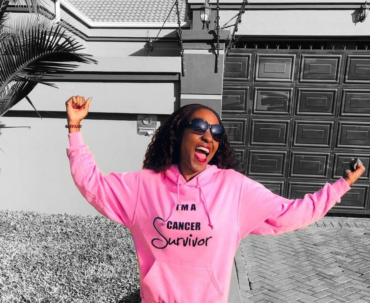 Marlene Chiedza Gadzirayi celebrating cancer survival in a bright pink hoodie that reads &lsquo;I&rsquo;m a Cancer Survivor