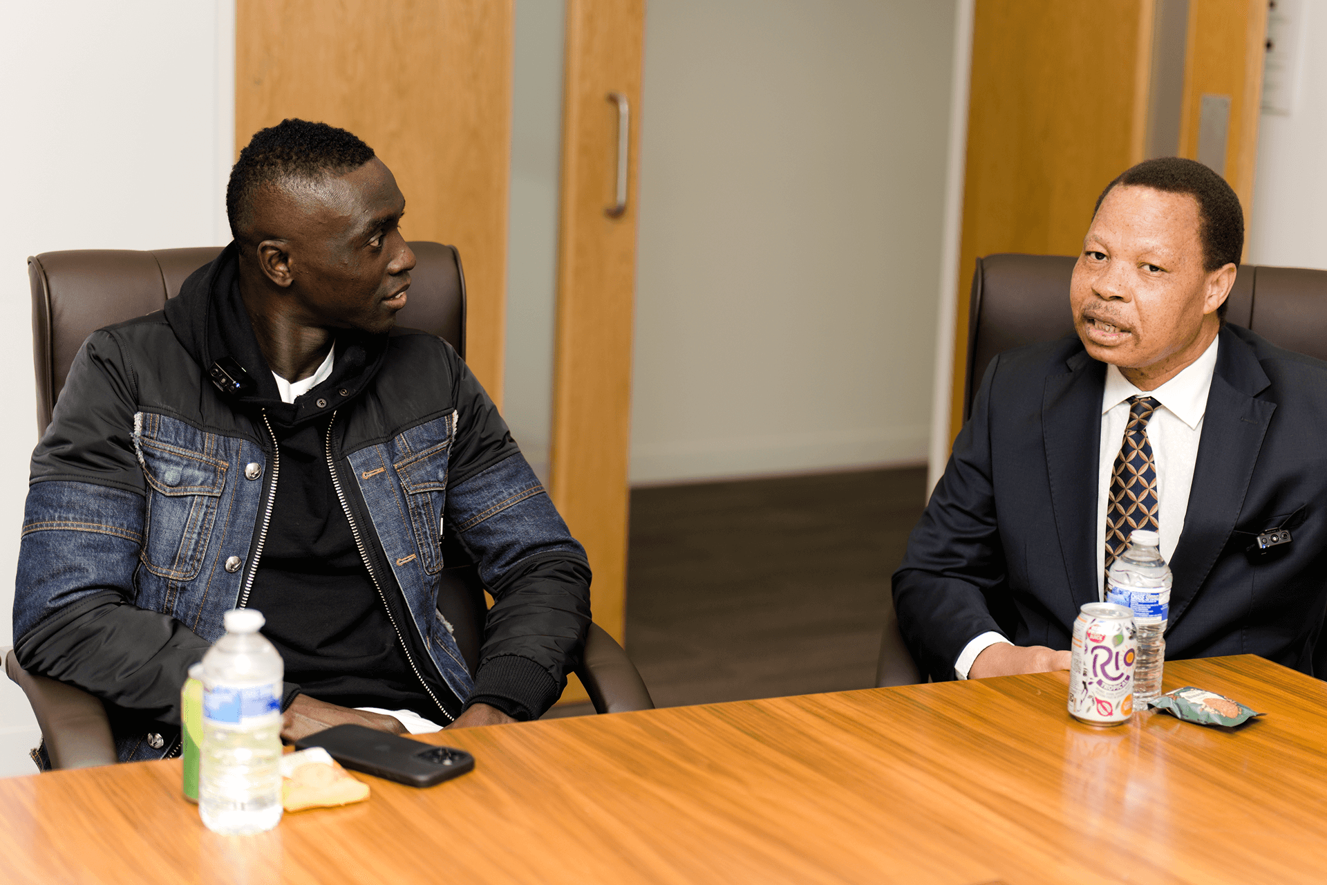 Diaspora Insurance CEO Jeff Madzingo speaking while Papiss Cissé listens attentively during a discussion on business and community leadership.