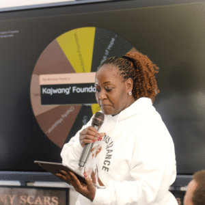 Pastor Caroline Shiko Kungu from Kenya reading the profile of a winning charity during the live draw.