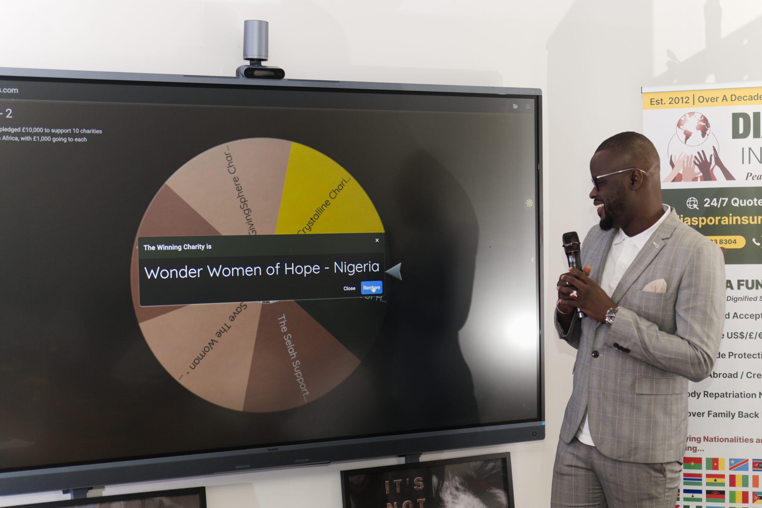 Senegal community leader in Manchester Pape Thiare presenting a winning charity at the live draw.