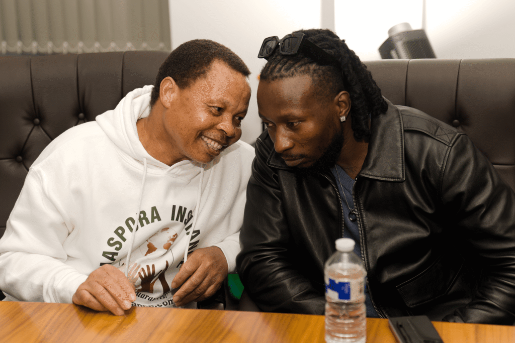 eff Madzingo whispering to musician Baba Harare during the live draw.