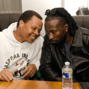 eff Madzingo whispering to musician Baba Harare during the live draw.