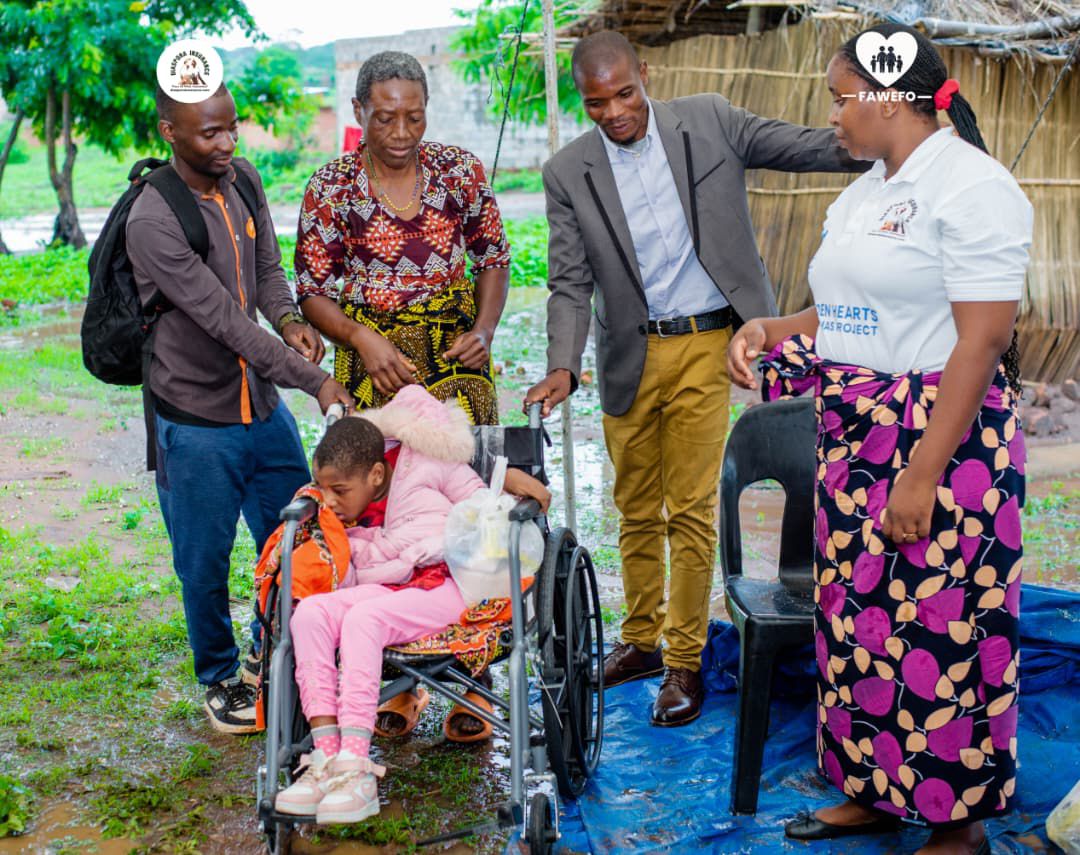 Grandmother Violet Mzungu receiving a brand-new wheelchair from Diaspora Insurance for her disabled granddaughter, Eliza.