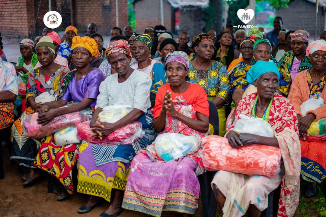 Elderly and underprivileged individuals receiving food hampers and blankets during a Christmas party in Malawi.