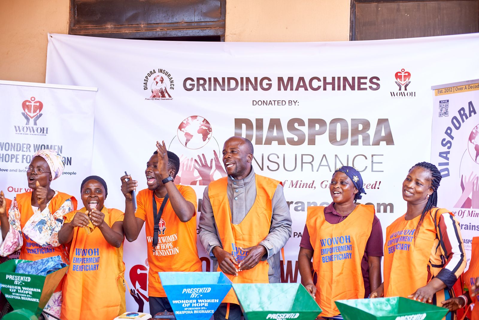 Beneficiaries celebrating with song and dance after receiving new grinding mill equipment from Diaspora Insurance.